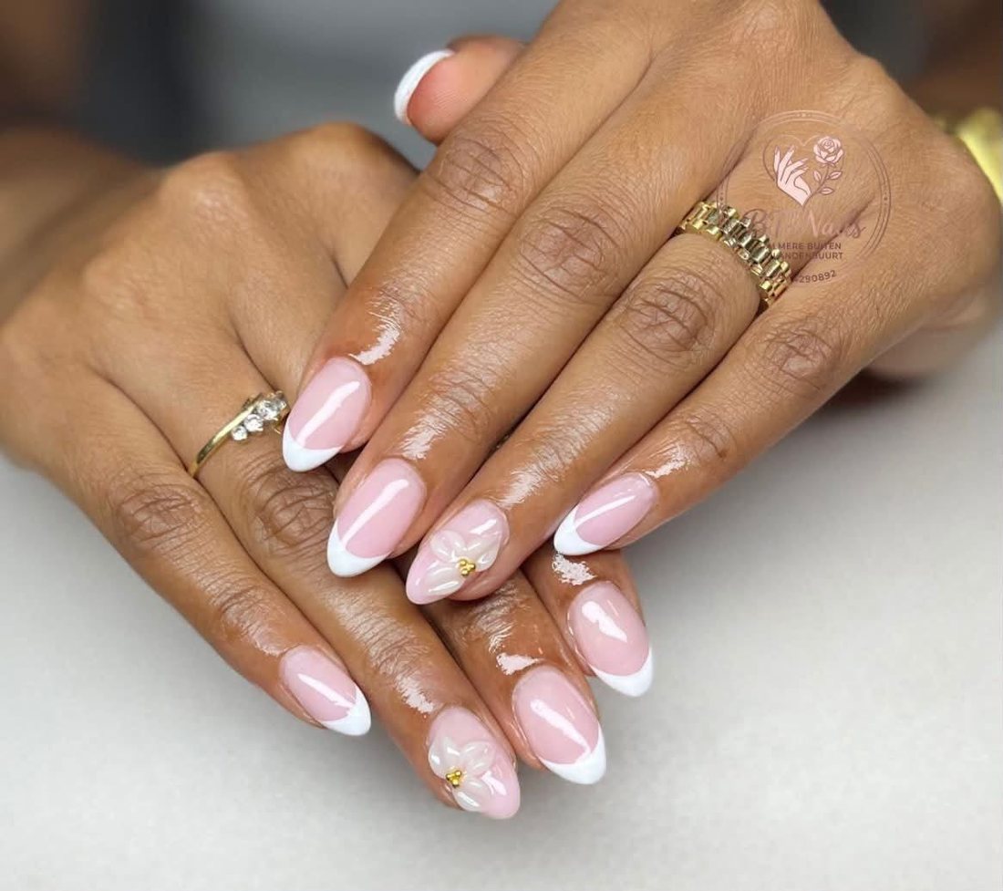 Roze French nagels met witte 3D-bloemen en gouden pareltjes